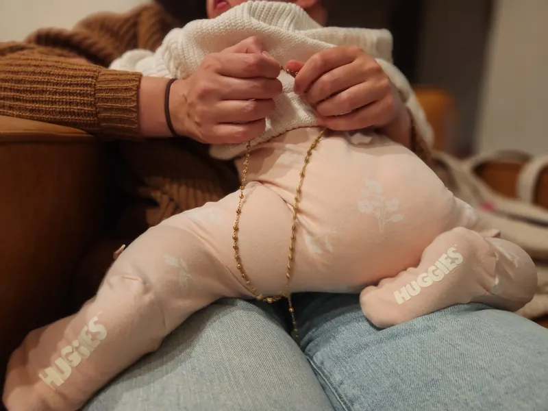 An infant resting on a parent's lap